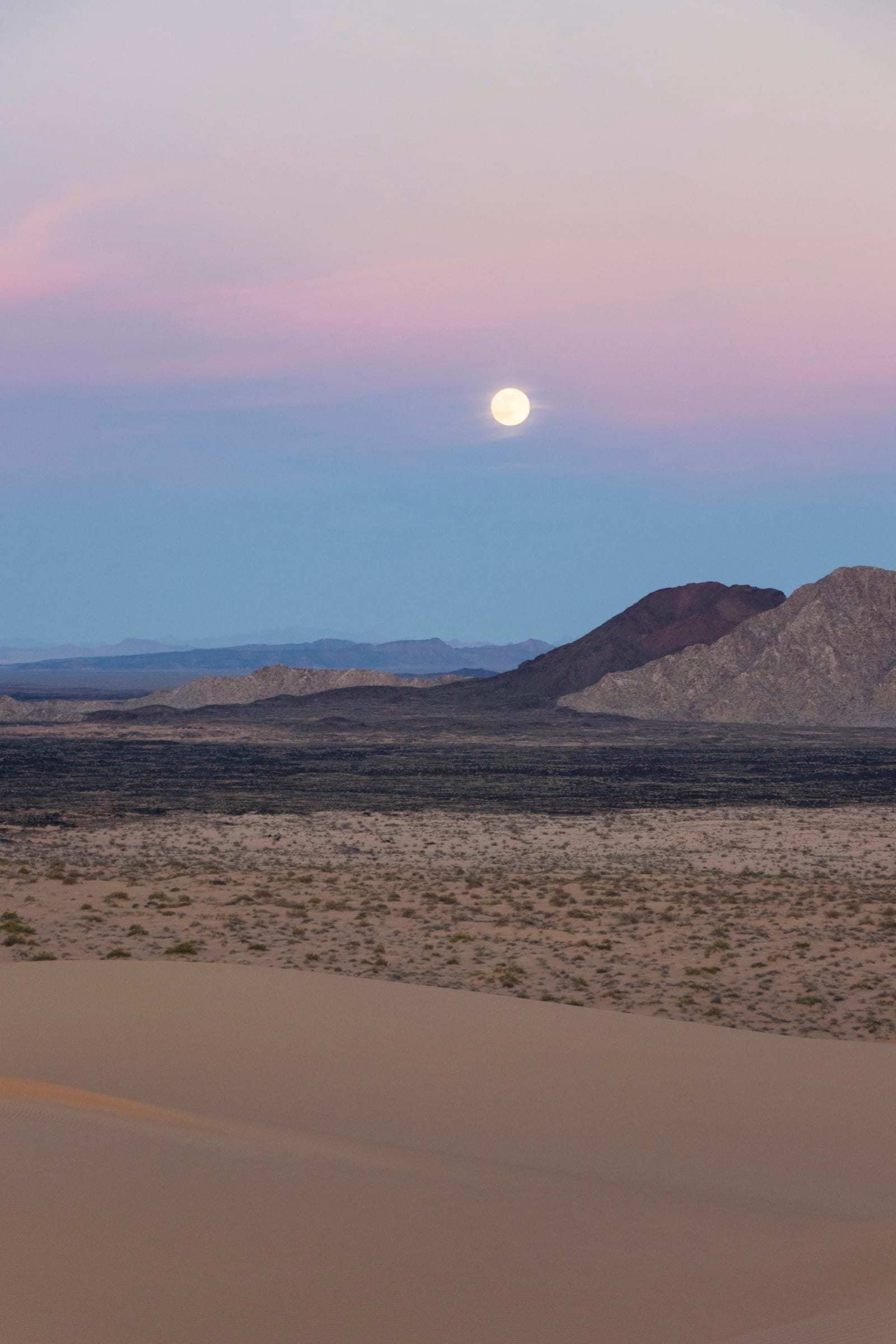 La luna llena sobre el paisaje volcánico al anochecer